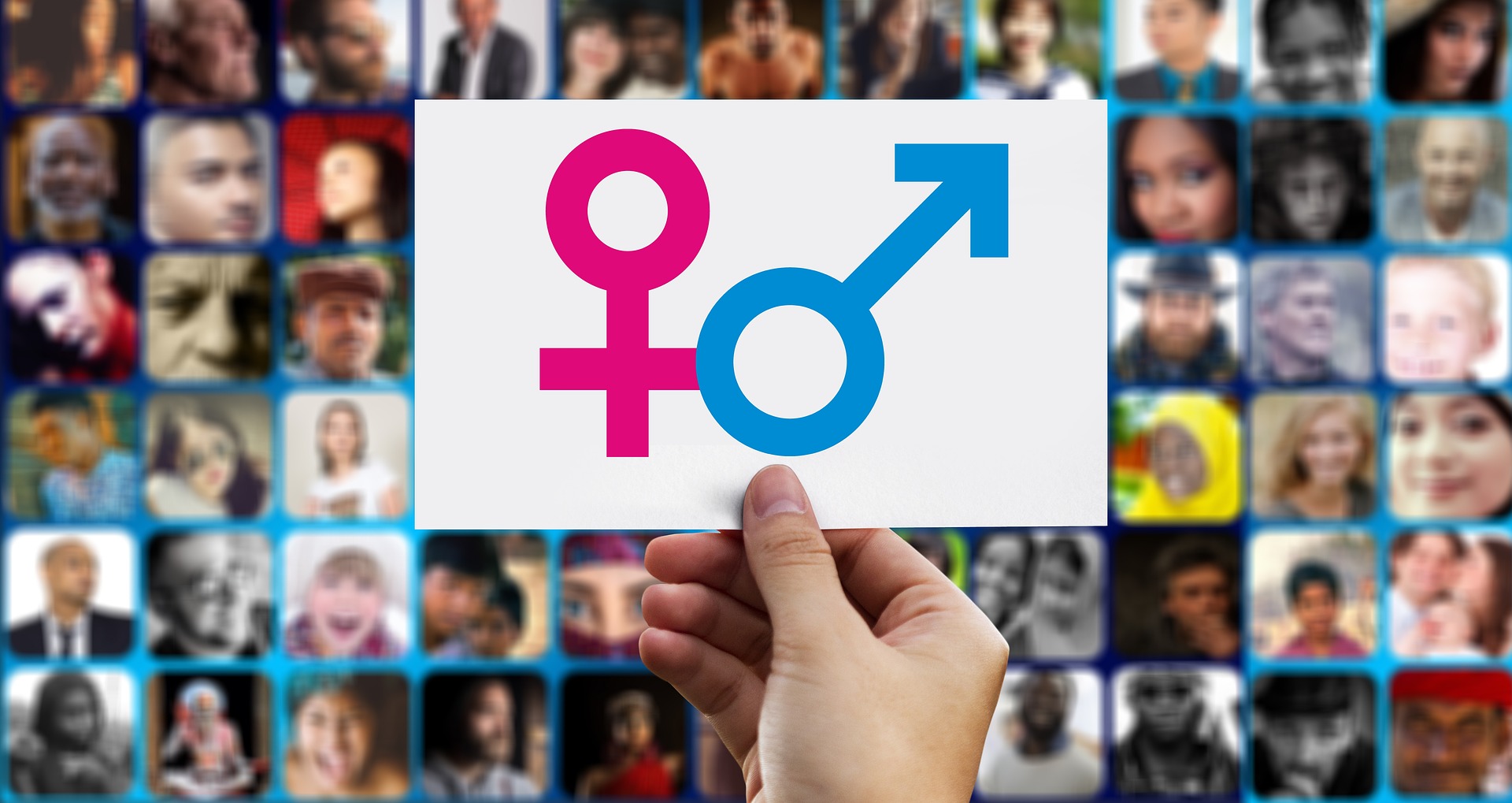 Symbole "weiblich" und "männlich" vor einem HIntergrund aus unscharfen Portraitfotos
